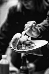 Photograph of someone tucking into a hog roast.