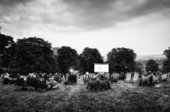 Black and white photo of event attendees sat in deckchairs ready for a film to begin.