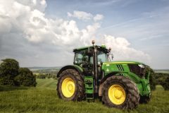Photogtaph of a green tractor in the middle of a field.