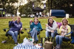 Photograph of a group of four smiling women raising their wine glasses - cheers!