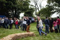 A group of attendees wave to the camera as they arrive on site.