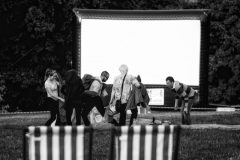 A group of eventgoers stake claim to a patch of grass in front of the big screen.