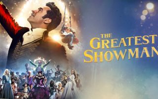 Cover artwork for the Greatest Showman movie. The movies title takes up the middle right of the poster. To the left, is a montage showing the lead characters in performance. Dominating the scene is the ringmaster.